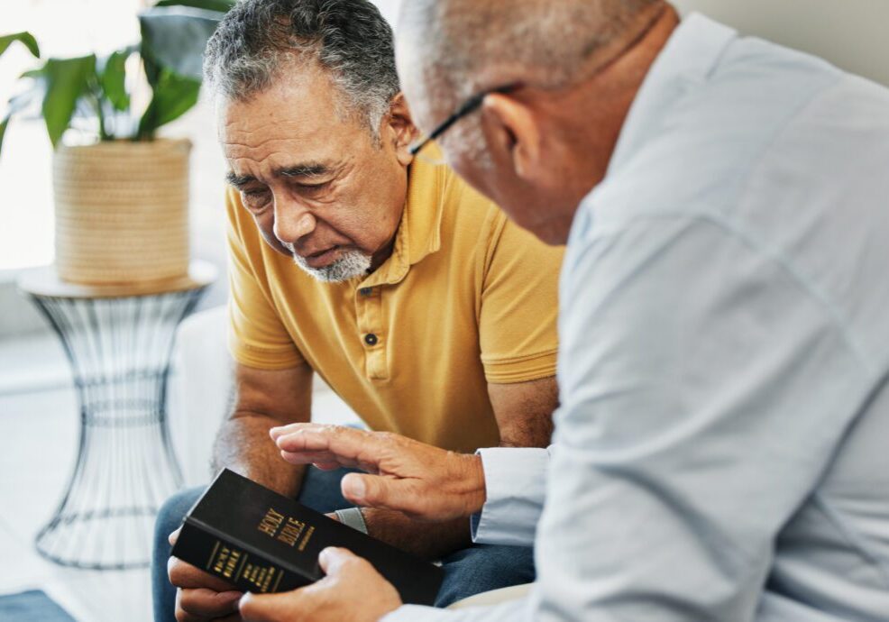 Men, home and bible with counselling on faith, worship and prayer with pastor, church or christ. Elderly men, diversity and spiritual guidance for grief with loss and depression with hope in jesus